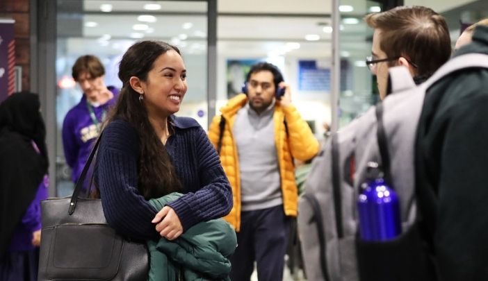 An open day attendee smiles as she talks to a Doctoral Academy representative