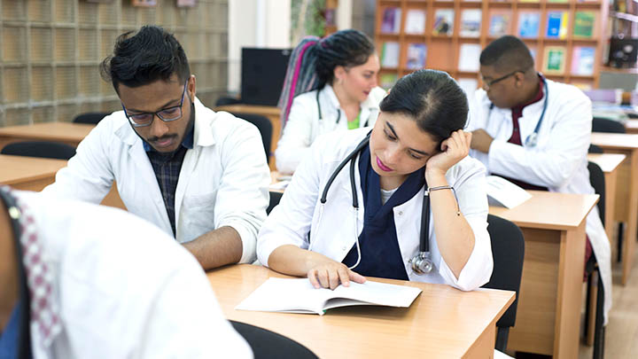 A group of medical students reading text books.