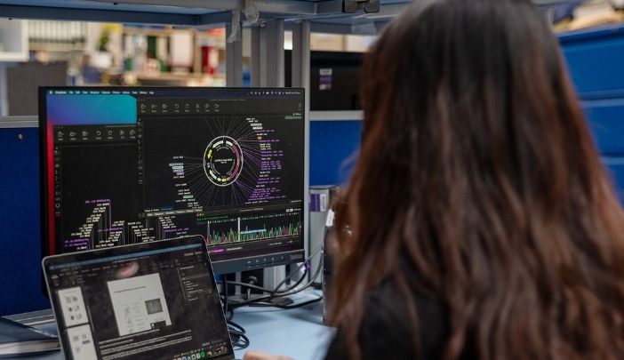 A postgraduate researcher looking at computer screens in their office