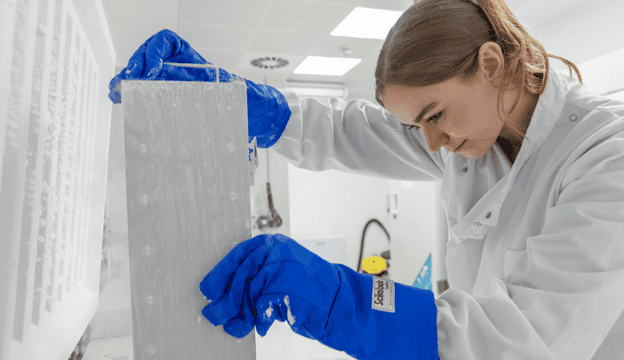 A postgraduate researcher reaches into a freezer and pulls a box out