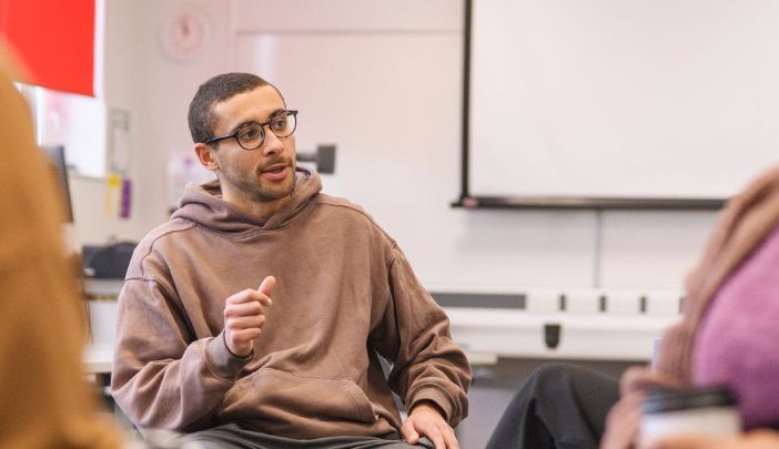 A postgraduate researcher sat in a workshop talking to a coach