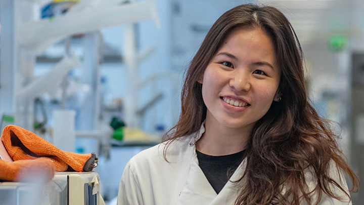 A postgraduate researcher looking into a microscope