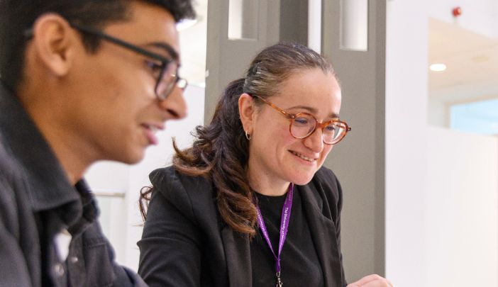 A postgraduate researcher sat with their supervisor looking at their laptop in front of them.