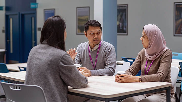 A group of students discussing postgraduate research.