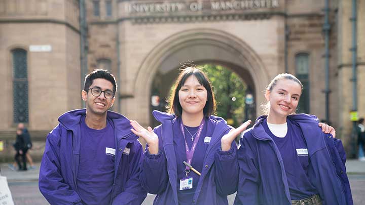 Student ambassadors outside the arch into the old quadrangle at The University of Manchester.