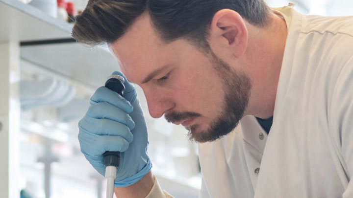 A PhD student working in a lab. 