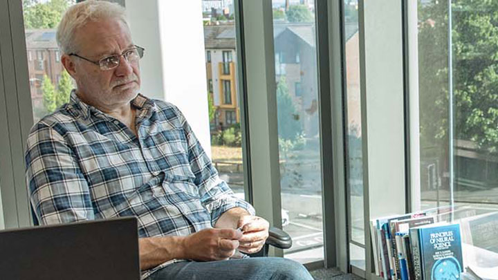 A PhD supervisor sitting in a bright office.