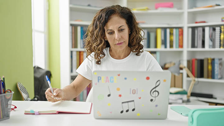 A social worker using a laptop, studying in a library.