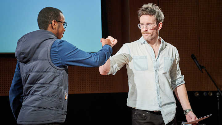 A photo of Richard on a stage, preparing to give a talk.