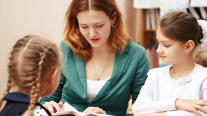 A speech and language therapist working with two children.