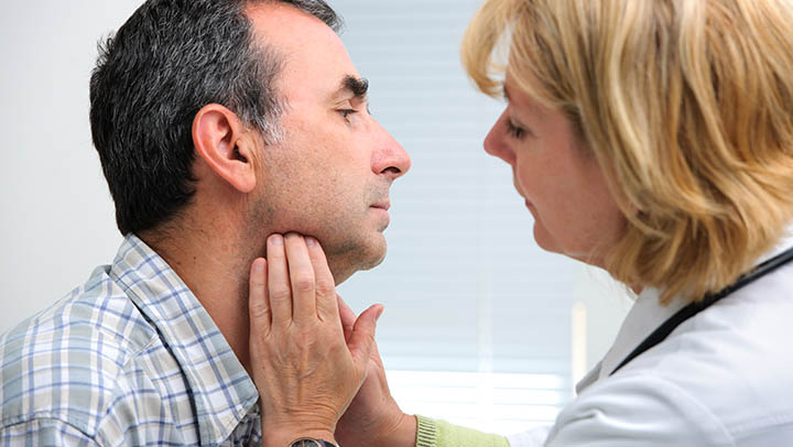 A speech and language therapist examining a patient's throat.