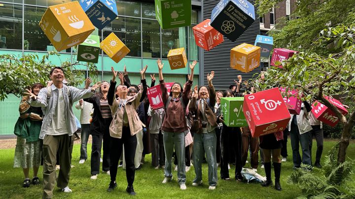 Students throwing colourful boxes in the air.