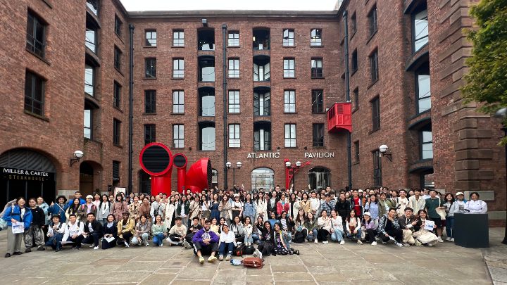 A group photo of students outside a museum
