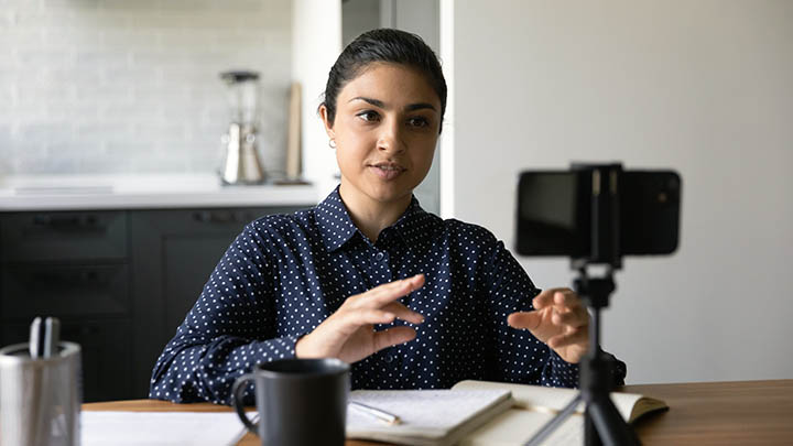 A student recording a podcast on their smartphone.