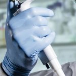 Gloved hand holding medical instrument