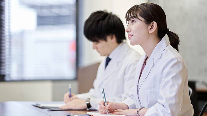 Medical students taking notes in a lecture.