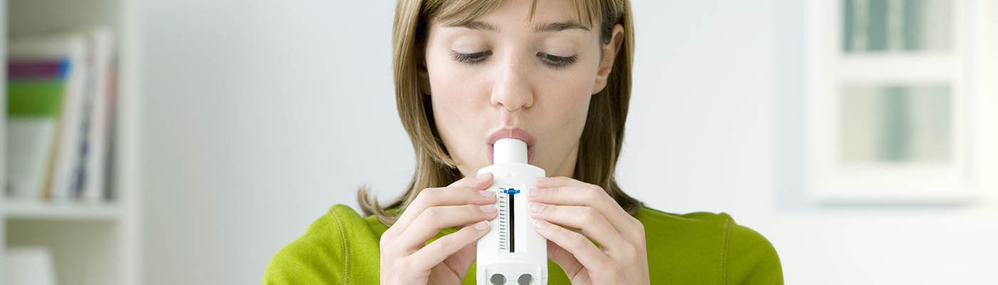 Girl blowing into a spirometer.